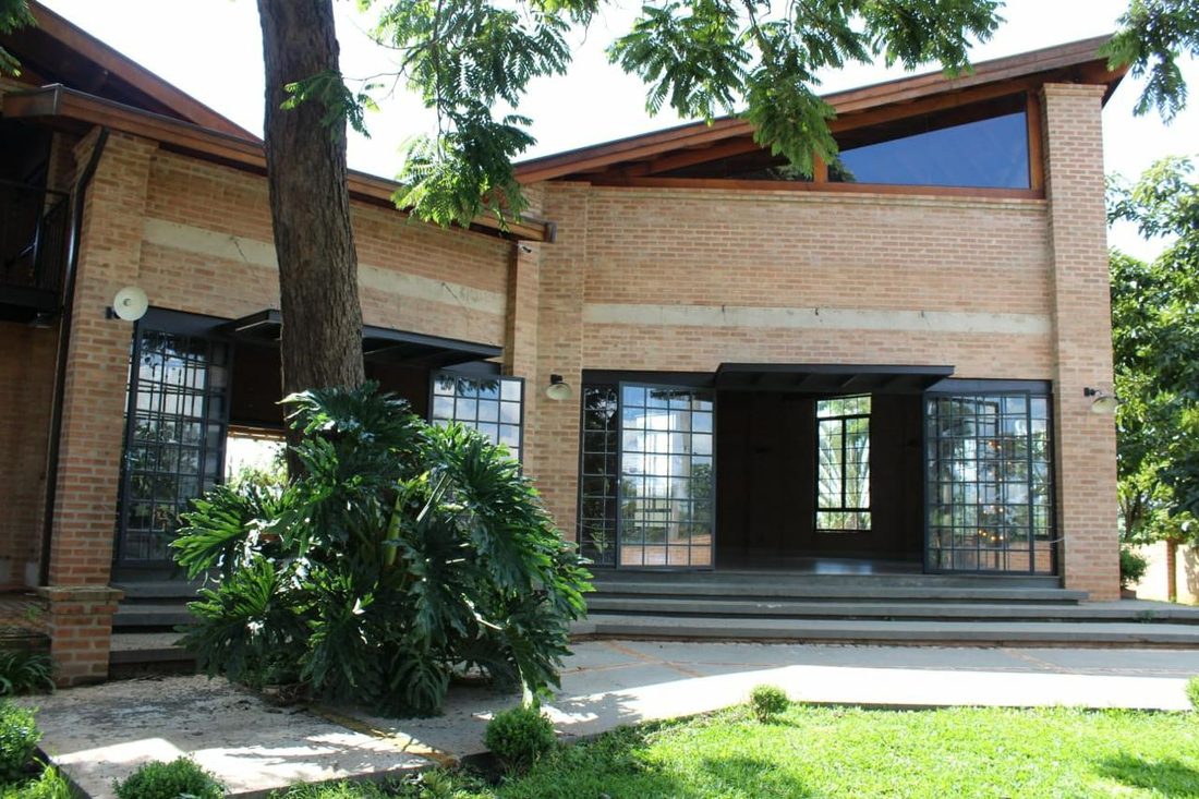 Fachada do salão em tijolo com portas de vidro e escadaria